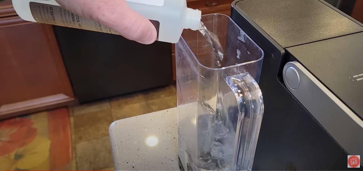 keurig descaling solution being poured into water reservoir