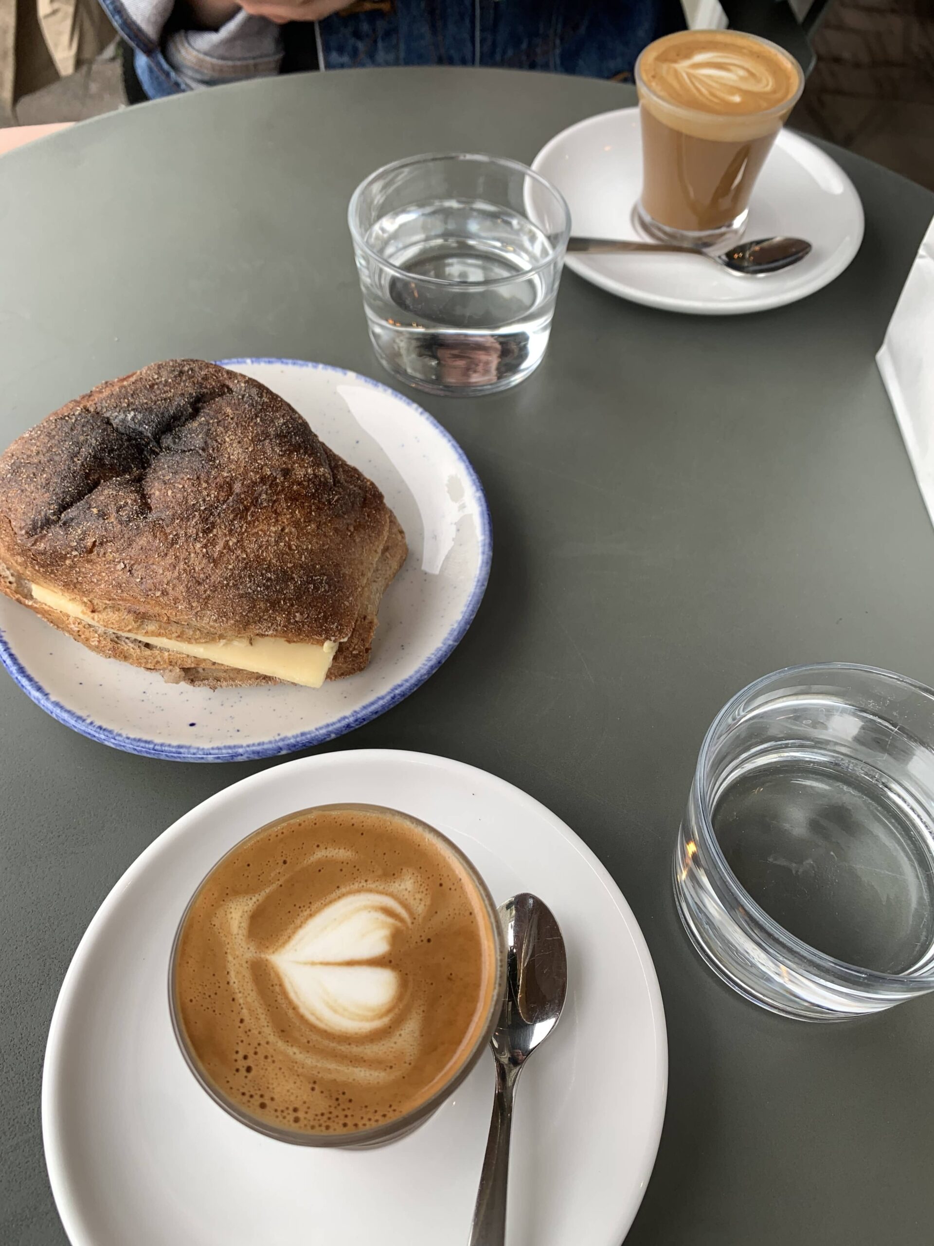 two cortados and a roll on a cafe table in copenhagen